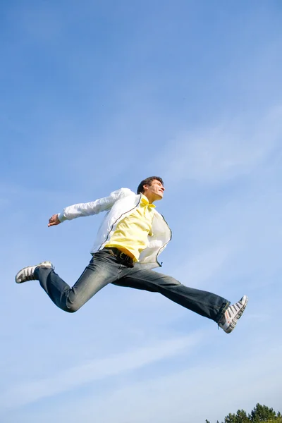 Son atlama mutlu bir genç adam - mavi gökyüzünde uçar. — Stok fotoğraf
