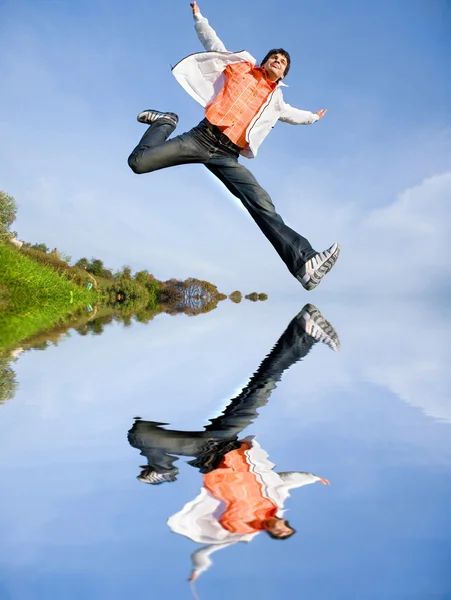 Szczęśliwy młody człowiek - skoki koniec latać w błękitne niebo. — Zdjęcie stockowe