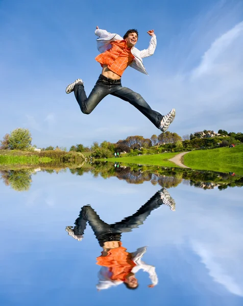 Gelukkig jonge man - springen einde vliegt in blauwe hemel. — Stockfoto