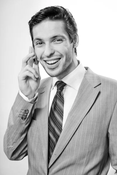 Handsome businessman speaks by a mobile phone — Stock Photo, Image