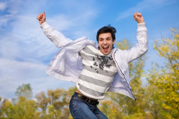 Gelukkig jonge man springt in de lucht — Stockfoto