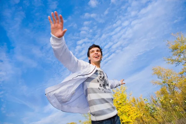 快乐年轻男子跳跃的天空和树木的背景 — 图库照片