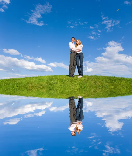 행복 한 젊은 커플을 찾고. 물에 반영녹색 풀밭 위에 뭔가 보고 행복 한 젊은 커플 — 스톡 사진