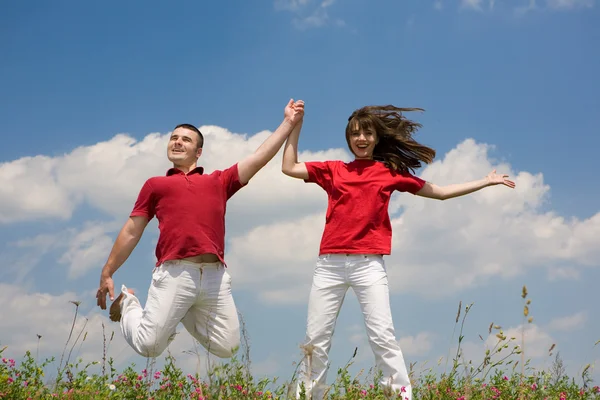 Mutlu Genç Aşk Çift Mavi Gökyüzü Altında Atlama — Stok fotoğraf