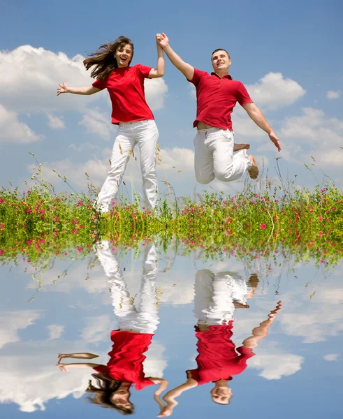 Happy Young Couple - команда прыгает — стоковое фото