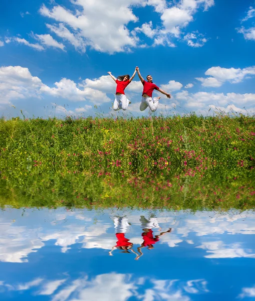 Gelukkige Jonge Paar Team Springen Hemel Boven Een Groene Weide — Stockfoto