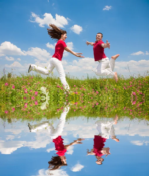 Lyckligt Leende Par Hoppa Himlen Ovanför Grön Äng — Stockfoto