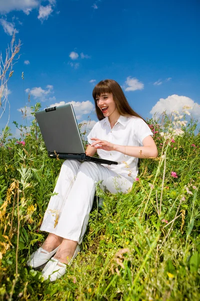 ノート パソコンで芝生のフィールドに幸せな若い女 — ストック写真