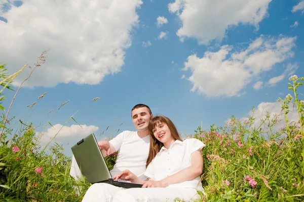 Casual couple heureux sur un ordinateur portable à l'extérieur — Photo