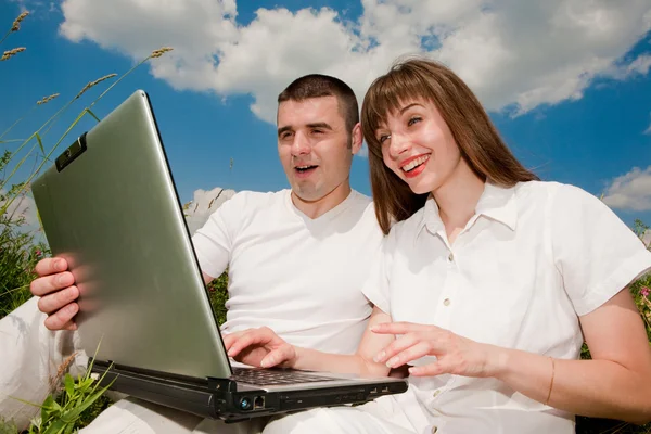ノート パソコンを屋外でのカジュアルな幸せなカップル — ストック写真