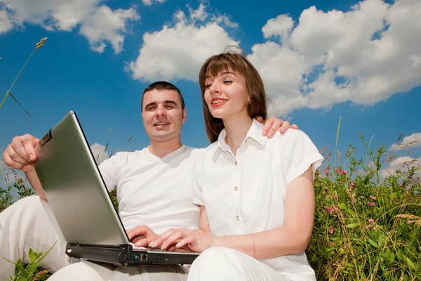 Casual coppia felice su un computer portatile all'aperto — Foto Stock