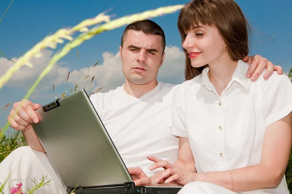 ノート パソコンを屋外でのカジュアルな幸せなカップル — ストック写真