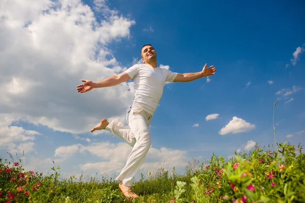 Happy young man is running in a field — Stock Photo, Image
