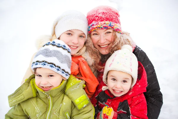 Retrato de madre feliz y niños juntos en la nieve en un frío —  Fotos de Stock