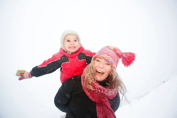 Portrait happy mother and child together in snow laughing, smil — Stock Photo, Image