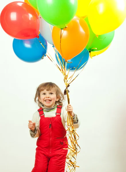 Little girl in red jumping with balloons — Stock Photo, Image