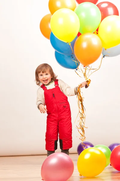 Petite fille en rouge avec des ballons — Photo