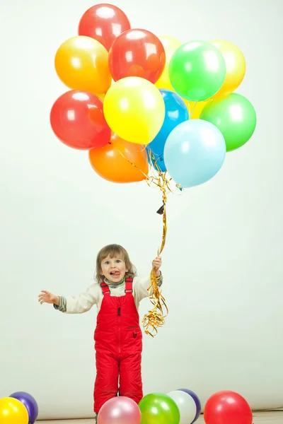 Little girl in red jumping with balloons — Stock Photo, Image