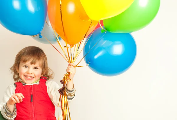 Klein meisje in rood met ballonnen — Stockfoto
