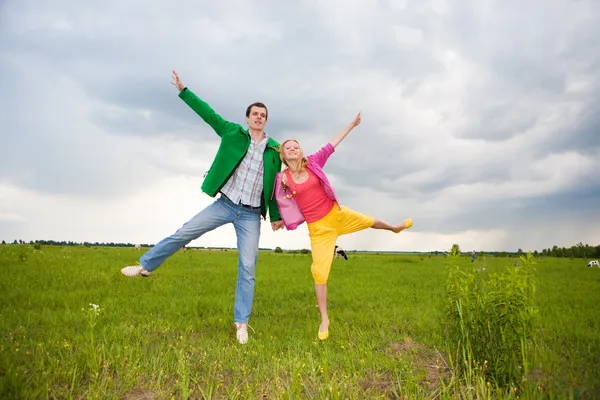Feliz pareja sonriente saltando en el campo —  Fotos de Stock