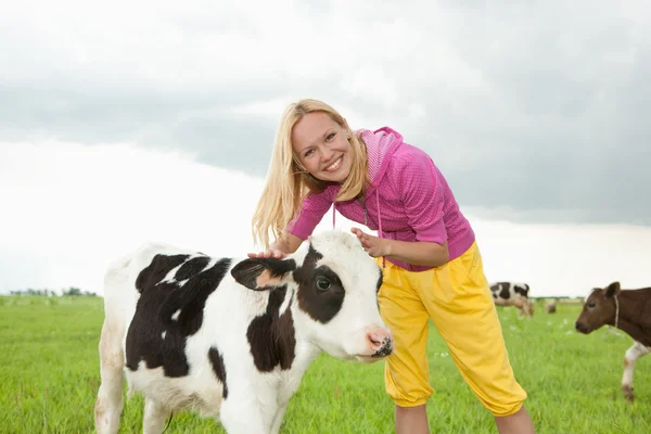 stock image Girl play with a little calf in the field