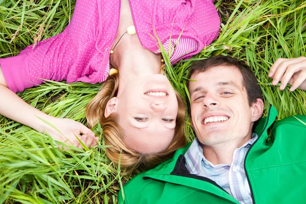 Młody miłość para lay na zielonej trawie na zewnątrz. — Zdjęcie stockowe