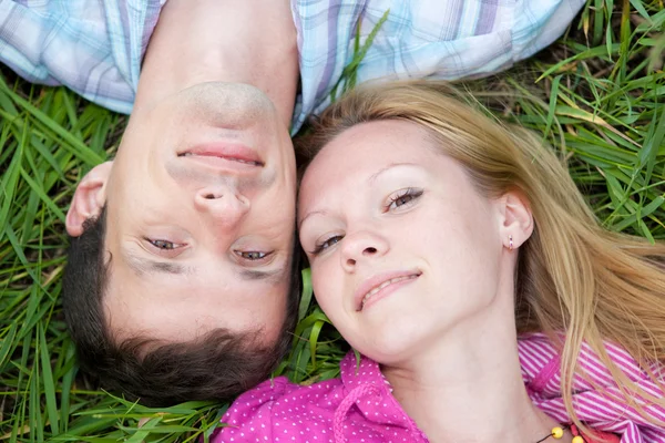 Молодая пара любви лежала на зеленой траве на открытом воздухе . — стоковое фото