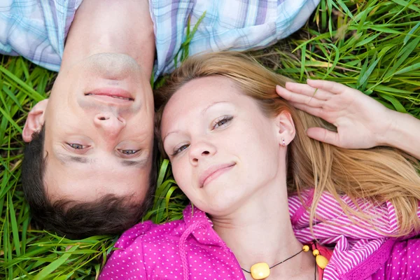 Jovem casal amor colocar na grama verde ao ar livre . — Fotografia de Stock