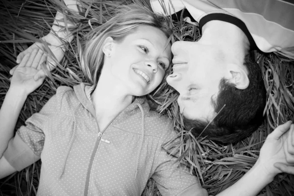年轻的爱情侣躺在户外草地上 — 图库照片