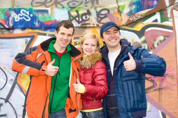 Szczęśliwy młody zespół tle muru grafit — Zdjęcie stockowe