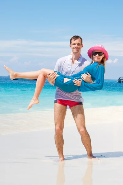 Молодая любовь Пара улыбается под голубым небом на морском пляже — стоковое фото