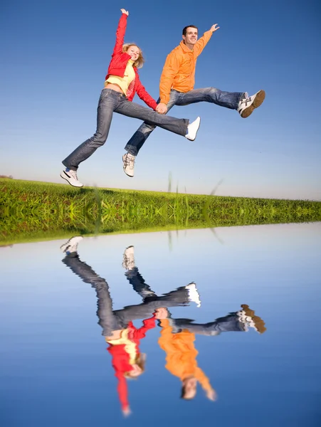 Feliz pareja sonriente saltando en el cielo azul —  Fotos de Stock