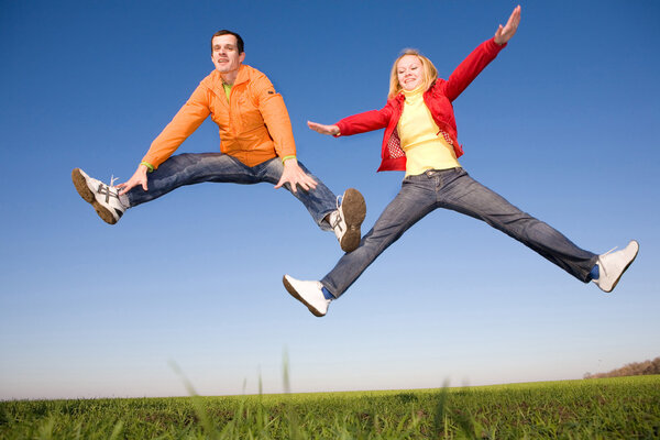 Happy smiling couple jumping in sky