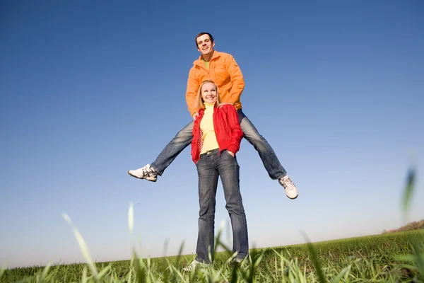 Happy smiling couple jumping in blue sky — Stock Photo, Image