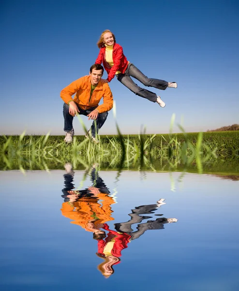 快乐的微笑夫妇在蓝蓝的天空中跳跃 — 图库照片