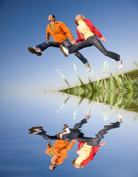 Glücklich Lächelndes Paar Springt Den Himmel Über Einer Grünen Wiese — Stockfoto