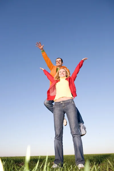 Feliz pareja sonriente saltando en el cielo azul —  Fotos de Stock