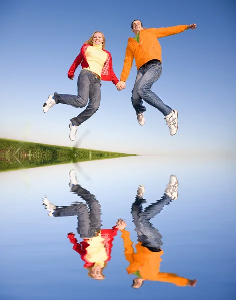 Счастливая Молодая Пара Прыгает Небо — стоковое фото