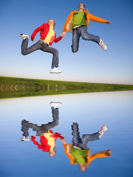 Felice Coppia Sorridente Saltando Nel Cielo Blu — Foto Stock