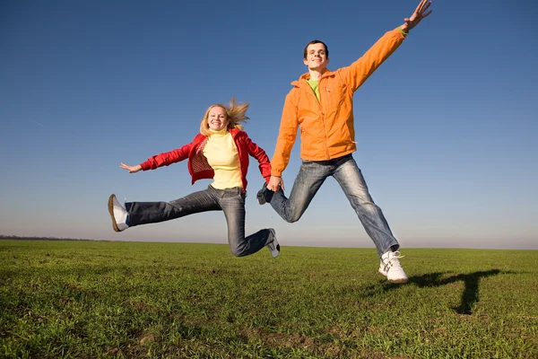 Glückliches Junges Paar Springt Den Himmel Über Einer Grünen Wiese — Stockfoto