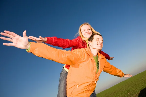 Feliz casal sorrindo voar na frente do céu — Fotografia de Stock