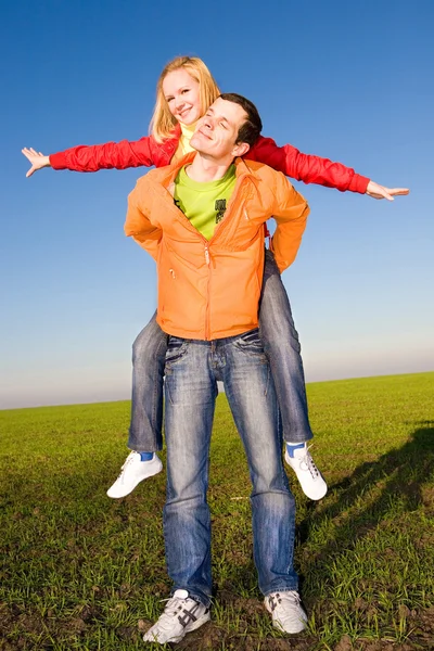 Feliz casal sorrindo pulando no céu azul — Fotografia de Stock