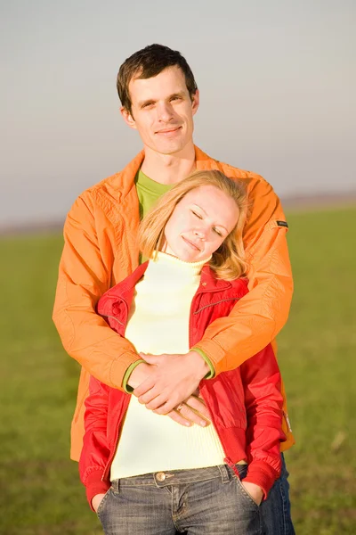 年轻的爱夫妇微笑的天空下 — 图库照片