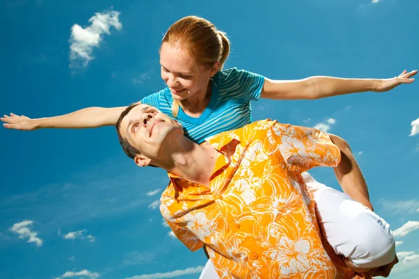 Para młoda miłość uśmiechający się pod błękitne niebo — Zdjęcie stockowe