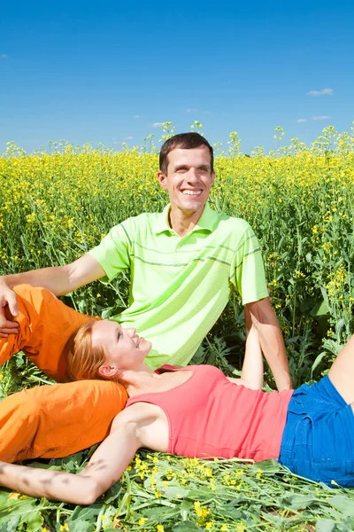 Young love couple relaxing while lying on grass — Stock Photo, Image