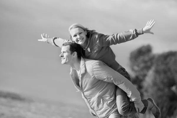 Mladá láska pár usmívá pod oblohou — Stock fotografie