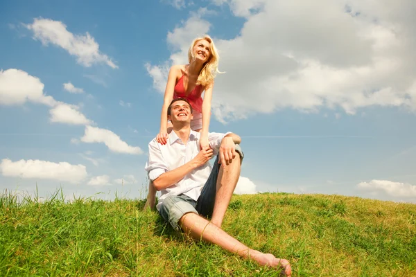 年轻的爱夫妇微笑在蓝蓝的天空下 免版税图库图片