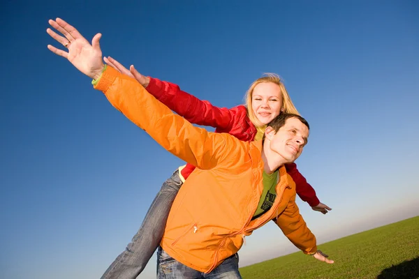 Young love couple smiling under blue sky Stock Image