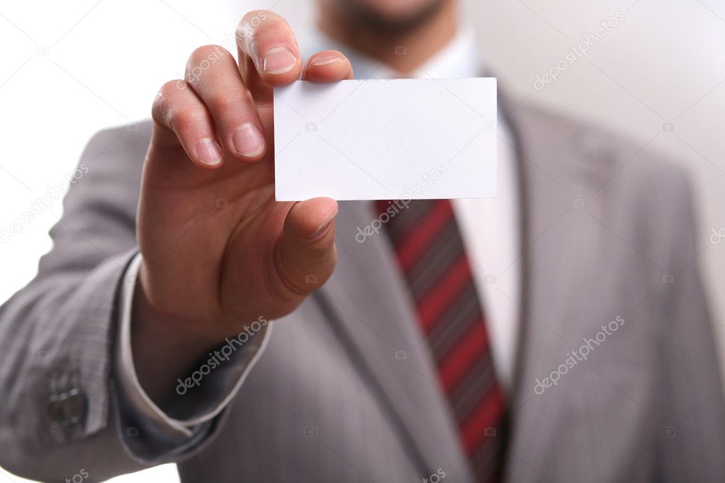 A studio shot of a businessman holding out a blank business card. Space for text, or your own message