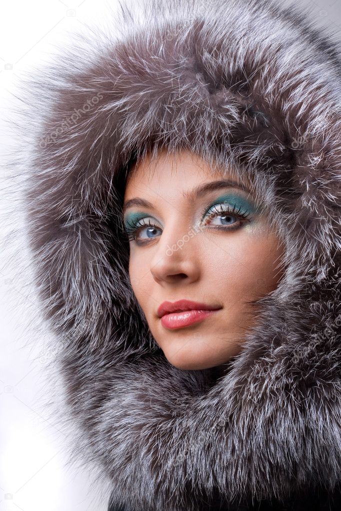 Portrait of the beautiful young woman with a fur hood